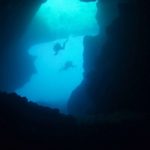 divers at the entrance of a cavern in gozo