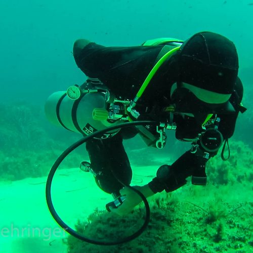 sidemount scooter diver storing his hoses